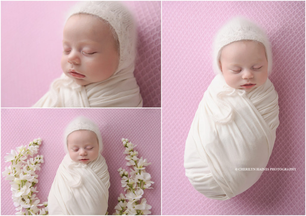 newborn baby girl photographed on pink blanket with white flowers