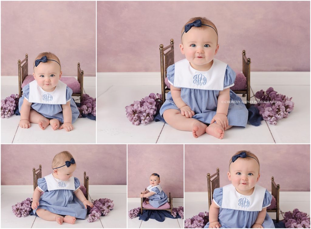 8 month old baby girl photographed on purple backdrop with a tiny gold bed and purple floral accents