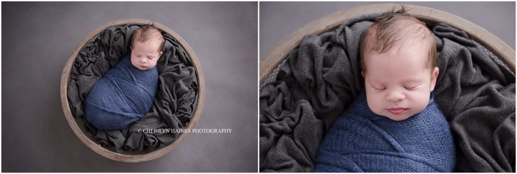 newborn baby boy swaddled and laying in basket