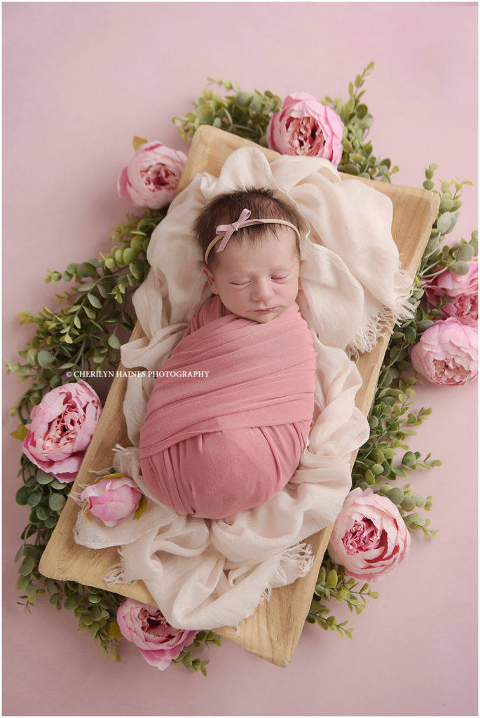 newborn portrait session in Baton Rouge, Louisiana with Cherilyn Haines Photography; 11 day old baby girl swaddled in pink with pink peonies