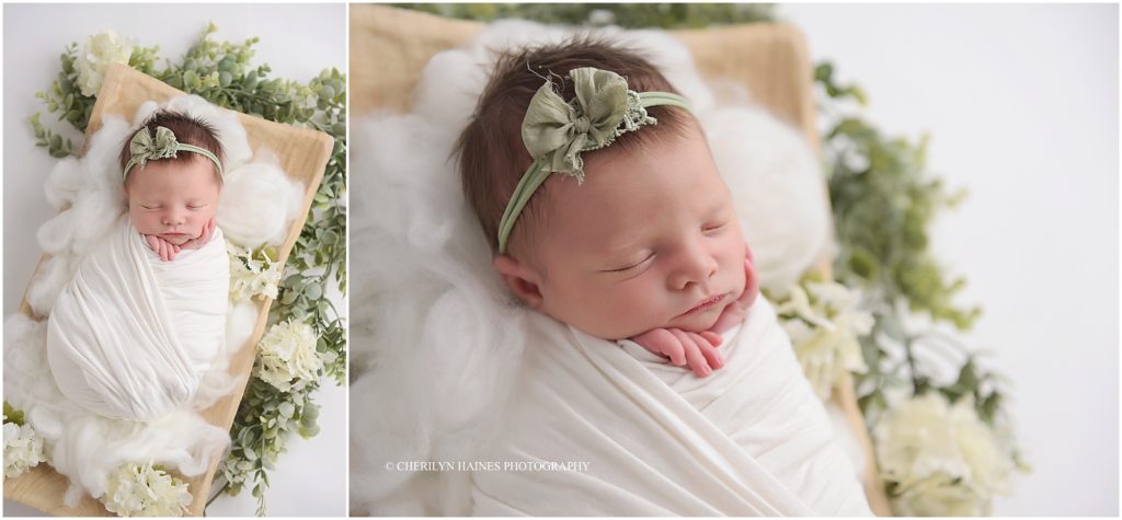 newborn baby girl photographed with greenery and white flowers; cherilyn haines photography in louisiana