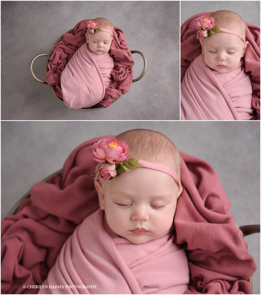 2 month old baby girl photographed swaddled in bucket with pink blankets