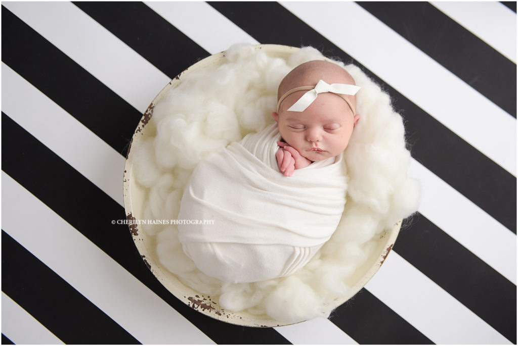 newborn session on black and white striped backdrop