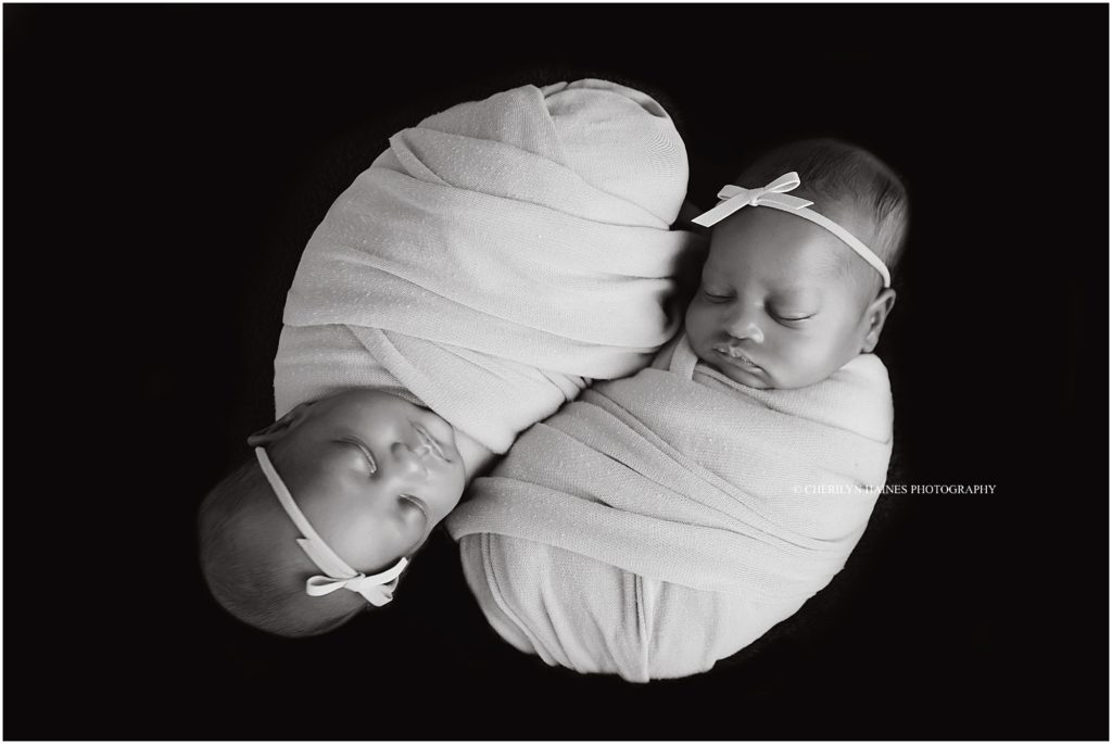 black and white image of newborn twin girls photographed by cherilyn haines photography