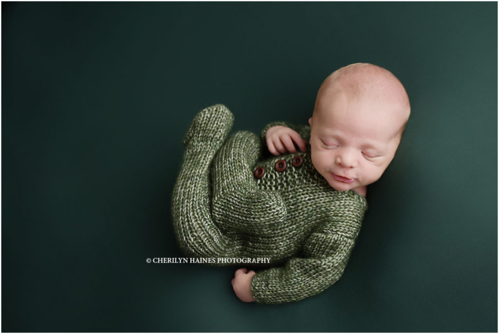 2 week old newborn baby boy photographed in green knit footed pajama outfit by cherilyn haines photography in Baton Rouge, Louisiana