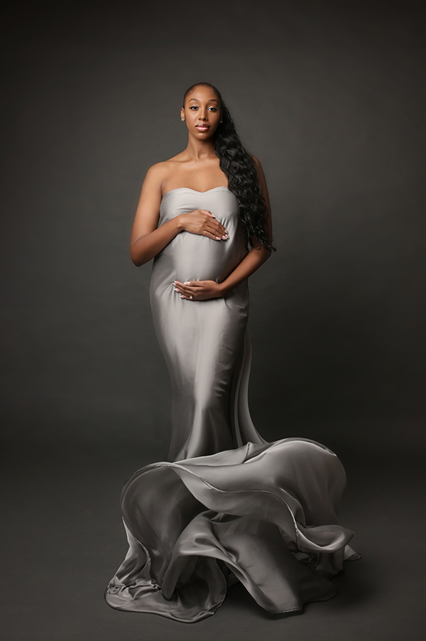 Luxury maternity portrait featuring silver satin tossing fabric