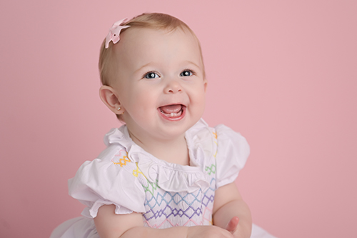 Smiling baby sitting during milestone photography session in Baton Rouge