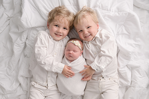 Newborn baby held by big brothers during Baton Rouge studio session