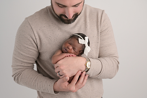 Newborn baby held in parents hands during Baton Rouge studio session