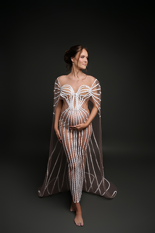 Pregnant mother wearing a glamorous beaded maternity gown during a luxury studio maternity session in Baton Rouge