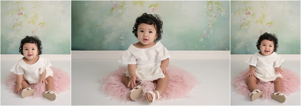 6-month-old baby girl with lots of hair photographed on a sage green floral backdrop