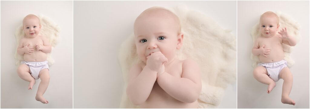 6 month old baby boy wearing a white diaper cover lying on his belly with hands clasped together on a soft white backdrop
