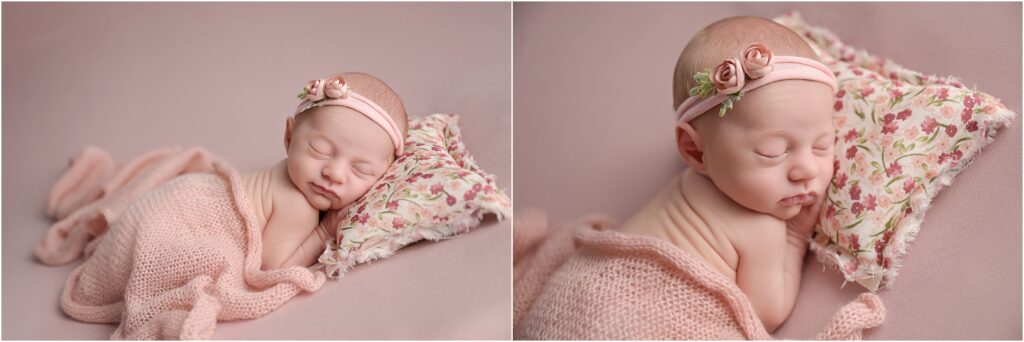 Newborn baby girl sleeping on a floral pillow with a pink blanket
