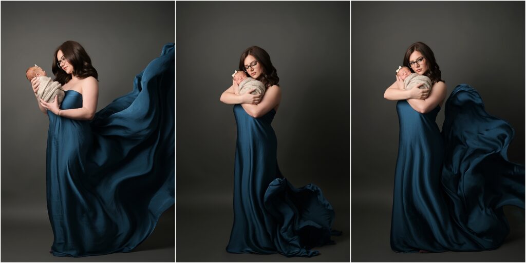 Newborn baby girl swaddled in her mother's arms while her mother wears a deep blue satin gown and flowing fabric