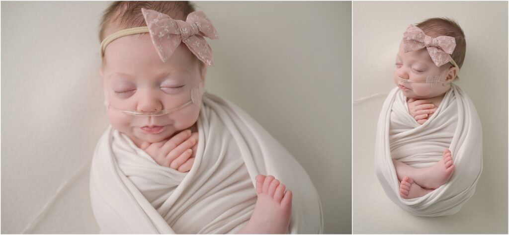 Baby girl swaddled in white with her tiny fingers and toes visible and a pink bow at Cherilyn Haines Photography's studio
